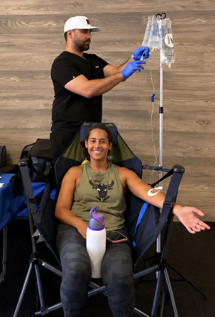 Salvatore setting up an IV for a smiling patient